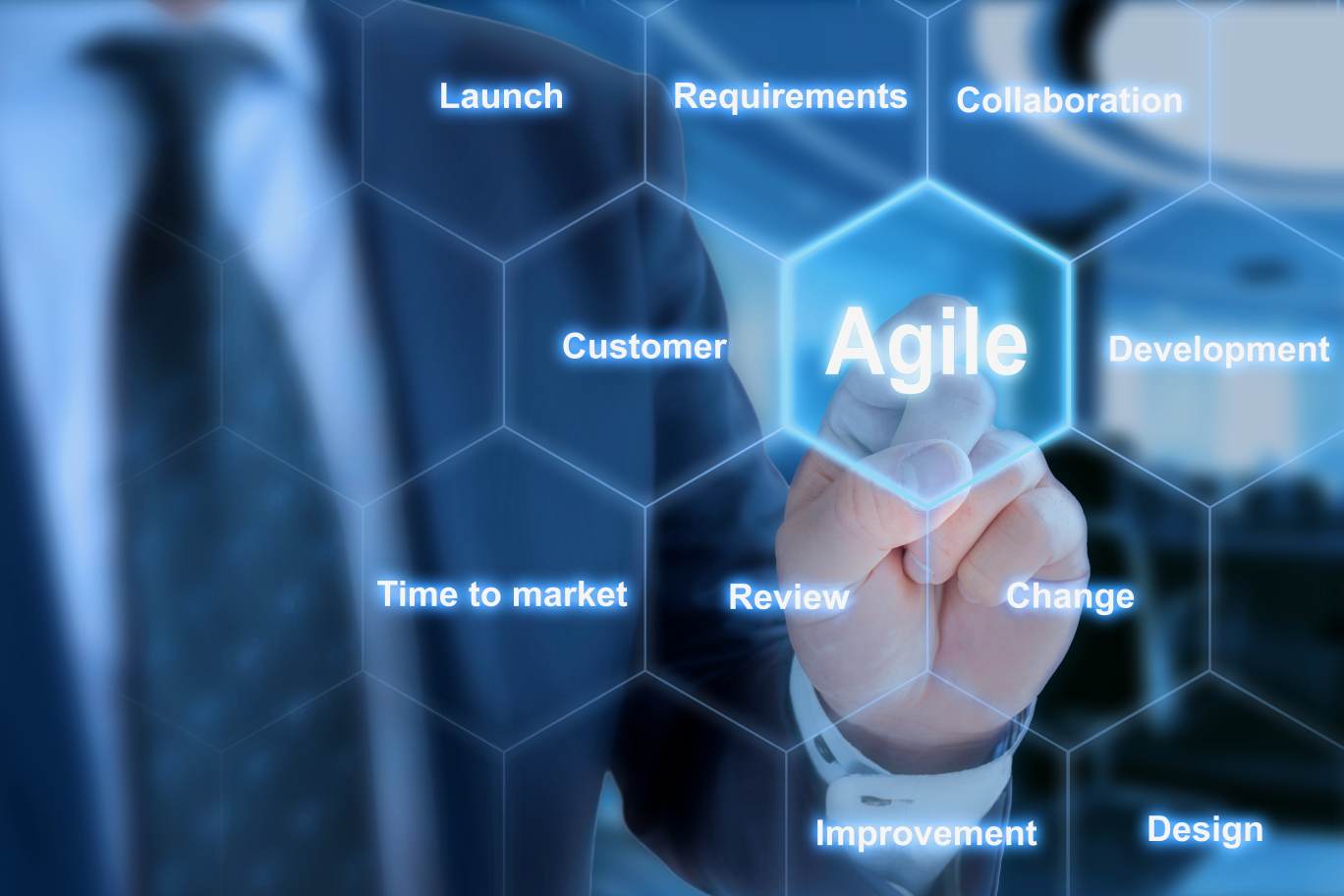 IT expert pressing a tile in an agile development keyword grid with tiles launch requirements collaboration customer agile development time to market review change improvement design